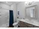 Neutral-colored bathroom featuring a walk-in shower, toilet, vanity, and framed mirror at 106 Beachview Dr, Mooresville, NC 28117