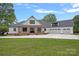 Charming exterior elevation of a farmhouse-style home with a three car garage and large front yard at 106 Beachview Dr, Mooresville, NC 28117