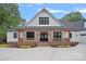 Elegant front exterior of a farmhouse-style home with a welcoming front porch with wood columns and brick trim at 106 Beachview Dr, Mooresville, NC 28117