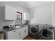 Neutral laundry room with gray appliances, a sink, wooden floors, and white cabinets at 106 Beachview Dr, Mooresville, NC 28117