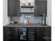 Modern wet bar featuring black cabinetry, granite countertop, backsplash and wine and beverage coolers at 106 Beachview Dr, Mooresville, NC 28117