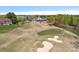 Aerial view of a golf course features lush greenery and sand traps surrounding the clubhouse at 10823 Caverly Ct, Huntersville, NC 28078