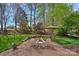 Brick patio featuring an outdoor fire pit surrounded by mature trees and grassy lawn at 10823 Caverly Ct, Huntersville, NC 28078