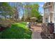 Well-maintained backyard with a brick patio, grill, outdoor seating, and lush landscaping at 10823 Caverly Ct, Huntersville, NC 28078