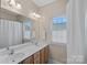 Bright bathroom features double sinks, a large mirror, and natural light from a window at 10823 Caverly Ct, Huntersville, NC 28078