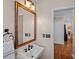 Stylish bathroom featuring a beautiful framed mirror, vanity with black fixtures, and adjacent doorway at 10823 Caverly Ct, Huntersville, NC 28078