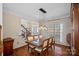 Elegant dining room with a modern chandelier, hardwood floors, and view of the entry hall at 10823 Caverly Ct, Huntersville, NC 28078