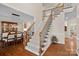 Elegant staircase with iron spindles and wood railing, leading to the upper level with views of the dining room at 10823 Caverly Ct, Huntersville, NC 28078