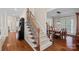 Elegant staircase with wooden railing and carpeted steps, leading to dining room with hardwood flooring at 10823 Caverly Ct, Huntersville, NC 28078