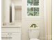 Bright bathroom with white vanity, toilet, decorative items, and a window at 109 Dogwood Grove Pl, Troutman, NC 28166