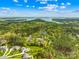 Aerial view of real estate showcasing homes with pools surrounded by lush trees and a nearby lake at 113 Sandy Cove Ct, Mooresville, NC 28117