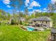 Spacious backyard featuring a pool, mature trees, and lush greenery at 113 Sandy Cove Ct, Mooresville, NC 28117