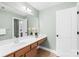 Well-lit bathroom featuring a long vanity with drawers, a single sink, and decorative floral arrangements at 113 Sandy Cove Ct, Mooresville, NC 28117