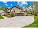 Spacious driveway leading to a three-car garage, accompanied by manicured landscaping at 113 Sandy Cove Ct, Mooresville, NC 28117
