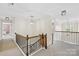 Upstairs hallway with neutral carpet and iron decorative staircase at 113 Sandy Cove Ct, Mooresville, NC 28117
