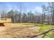 View of the backyard with trees and grass beyond a newly built wooden deck at 1173 Yorkdale Ln, Lincolnton, NC 28092