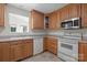 Functional kitchen with oak cabinets, neutral countertops, and modern white appliances at 1207 Overhill Rd, Salisbury, NC 28144