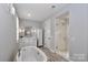 Bright bathroom features a soaking tub, glass shower, white cabinets, and a neutral color palette at 13306 Old Store Rd, Huntersville, NC 28078