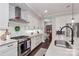 Well-equipped kitchen featuring a gas range, stainless steel hood, island with sink, and stylish cabinetry at 13306 Old Store Rd, Huntersville, NC 28078