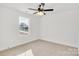 Bedroom featuring neutral carpet, white walls, a ceiling fan and a window for natural light at 1540 Solitude Ct, Kannapolis, NC 28081