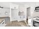 White kitchen with stainless steel appliances, granite countertops, and light hardwood floors at 1540 Solitude Ct, Kannapolis, NC 28081