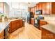 Spacious eat-in kitchen with cherry wood cabinets, black appliances and light hardwood floors at 1655 Essex Hall Dr, Rock Hill, SC 29730