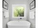 Bright bathroom with a soaking tub, tranquil lighting, and neutral decor at 174 Logan Crossing Dr, Davidson, NC 28036