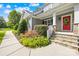 Charming front porch with stone steps, a red door, and landscaped bushes adding to the curb appeal at 174 Logan Crossing Dr, Davidson, NC 28036