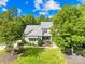 Beautifully landscaped front yard with mature trees and shrubs surrounding a charming two-story home at 174 Logan Crossing Dr, Davidson, NC 28036