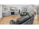 Inviting living room featuring a fireplace, TV, hardwood floors and a comfortable black leather sofa at 174 Logan Crossing Dr, Davidson, NC 28036