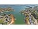 Aerial view of waterfront homes along a picturesque lake, showcasing docks, boats, and lush greenery at 17701 Springwinds Dr, Cornelius, NC 28031