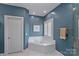 A soothing bathroom has a soaking tub with tile surround and ample natural light at 17701 Springwinds Dr, Cornelius, NC 28031