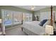 A bright bedroom features large windows overlooking the lake views and a cozy carpet at 17701 Springwinds Dr, Cornelius, NC 28031