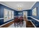 Stylish dining room with dark blue walls, hardwood floors, and modern lighting fixture at 17701 Springwinds Dr, Cornelius, NC 28031