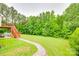 Expansive backyard featuring a stone walkway, a deck, lush green grass, and mature trees for added privacy at 2050 Sunswept Ln, York, SC 29745