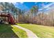 Wide open backyard with a paver walkway to a deck with stairs, and a wooded lot at 2050 Sunswept Ln, York, SC 29745