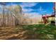 A spacious backyard with a deck and stairway, featuring lush green grass and a wooded backdrop at 2050 Sunswept Ln, York, SC 29745