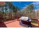 View of a deck with red floors and railings, featuring a grill and wooded background at 2050 Sunswept Ln, York, SC 29745