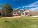 Charming two-story home featuring a landscaped yard, complemented by red shutters against the tan siding at 2050 Sunswept Ln, York, SC 29745