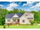 Charming tan two-story home with a well-manicured lawn and landscaping, accented by dark shutters and roof at 2050 Sunswept Ln, York, SC 29745