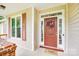 The front porch features a decorative door with a wreath, sidelights, and a 