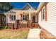 Charming front porch with brick accents, columns, and warm wood steps leading to the front door at 2050 Sunswept Ln, York, SC 29745