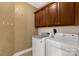 Functional laundry room with washer, dryer, and overhead cabinets for optimal storage at 2050 Sunswept Ln, York, SC 29745