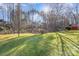Expansive backyard with mature trees and lush green lawn creating a private, park-like setting at 227 Spicewood Cir, Troutman, NC 28166