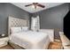 Bedroom with grey walls, ceiling fan and a bed with a tufted headboard creating a cozy atmosphere at 227 Spicewood Cir, Troutman, NC 28166
