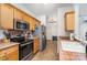 Functional kitchen with stainless steel appliances, tile countertops, and ample wood cabinet space at 227 Spicewood Cir, Troutman, NC 28166