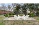 Relaxing backyard featuring a fire pit surrounded by white Adirondack chairs and lush greenery at 2509 Lanecrest Dr, Charlotte, NC 28215