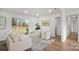 Cozy living room with white furniture, a glass coffee table, and sliding glass doors to the backyard at 2509 Lanecrest Dr, Charlotte, NC 28215