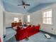 Messy bedroom with blue cloud painted ceiling, bright natural light and a red couch at 265 Sailboat Dr, Salisbury, NC 28146