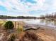 Scenic waterfront view with a wooden dock and sandy beach, perfect for enjoying lakeside living at 265 Sailboat Dr, Salisbury, NC 28146